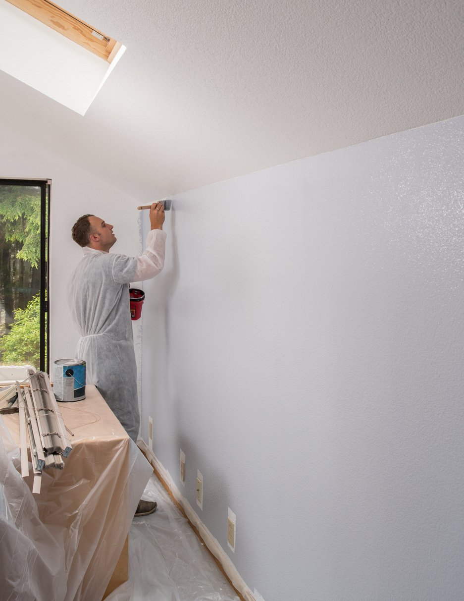 Man painting interior of home